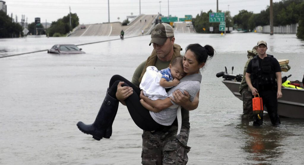Houston Flooding - Rescuer carries a woman and her baby to safety