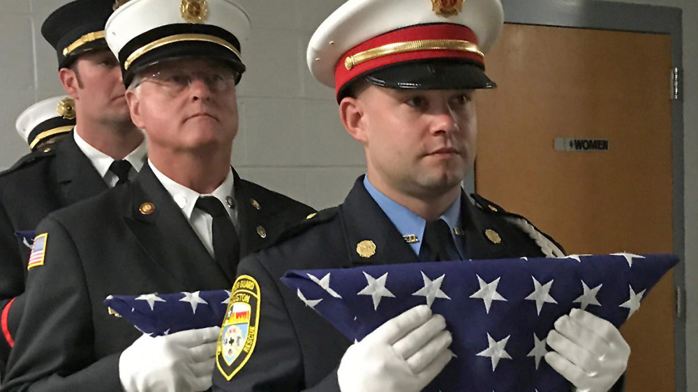 Firefighters with folded American Flags