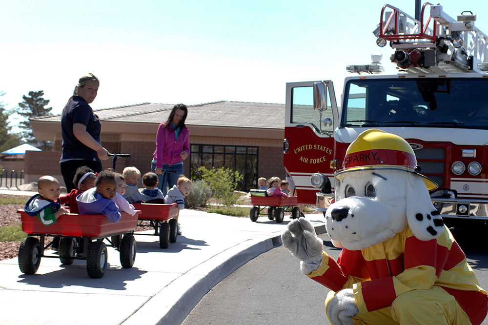 Sparky the Fire Dog, with fire appliance and a group of small children